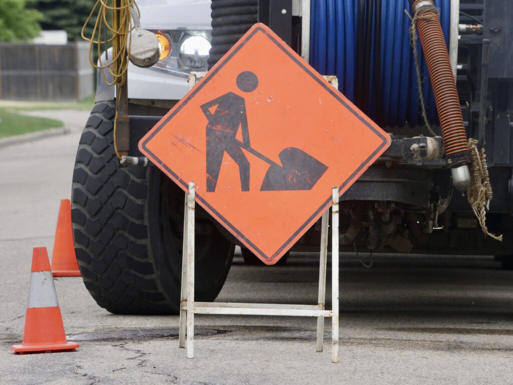 ‘Men Working’ sign in front of a truck
