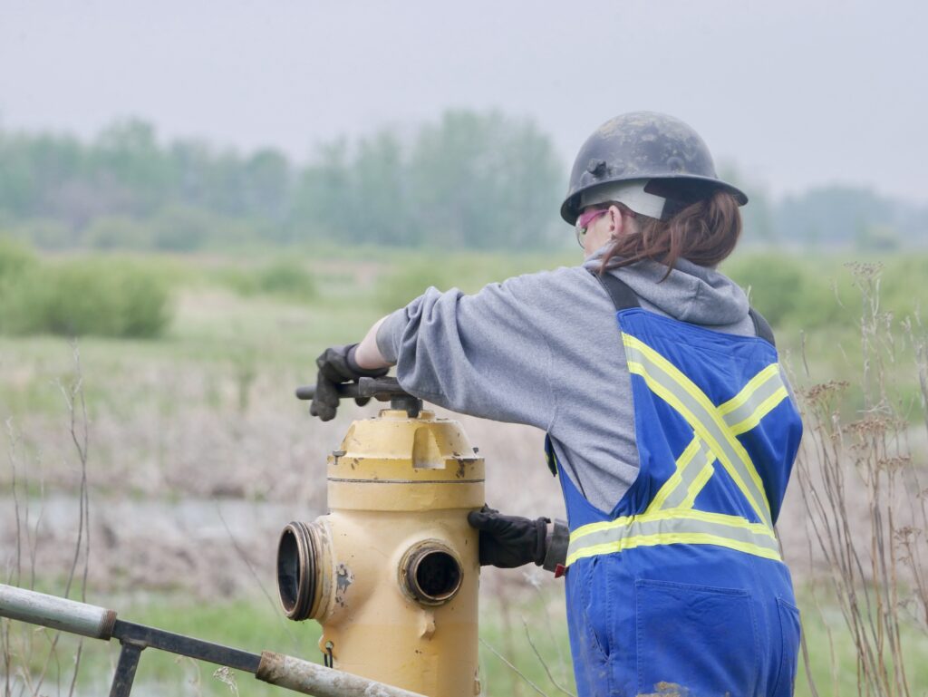 Field worker performing hydrant maintenance at a job site
