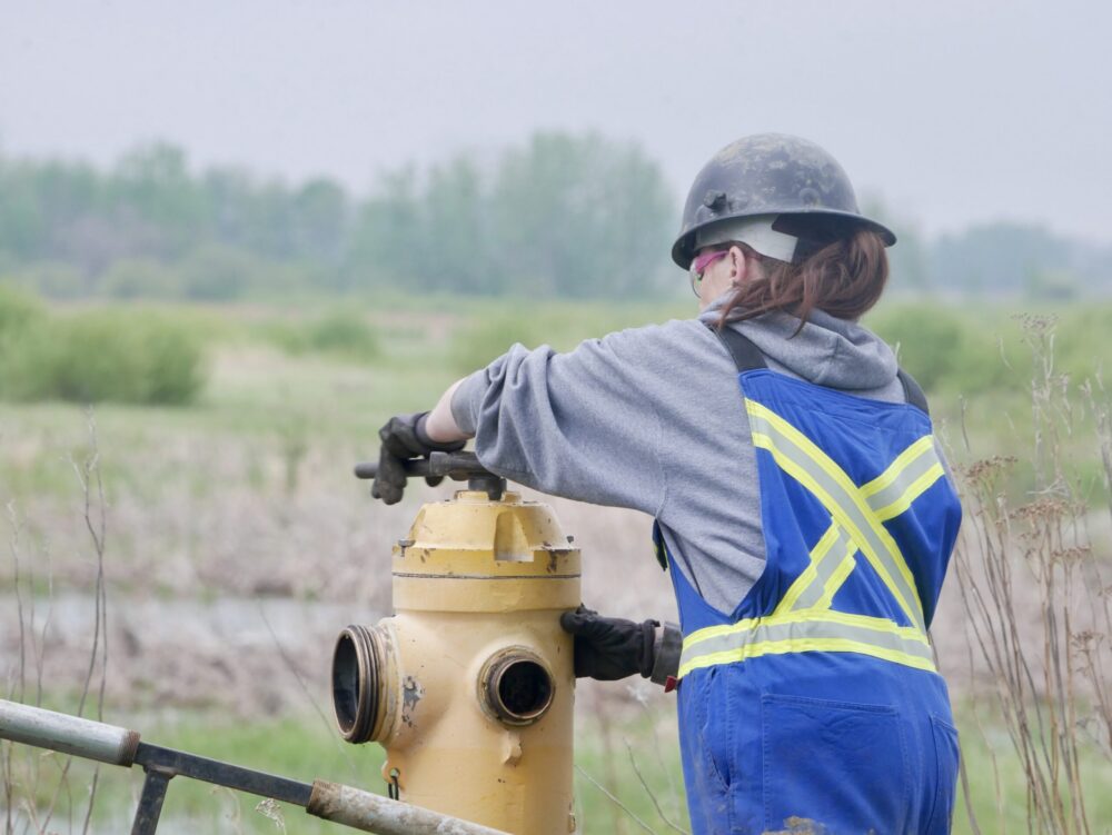 Field worker performing hydrant maintenance at a job site