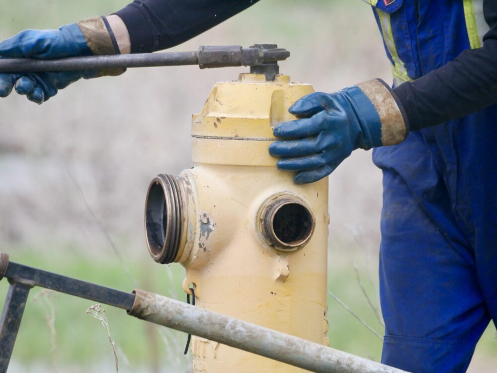 Hands performing maintenance work on a fire hydrant