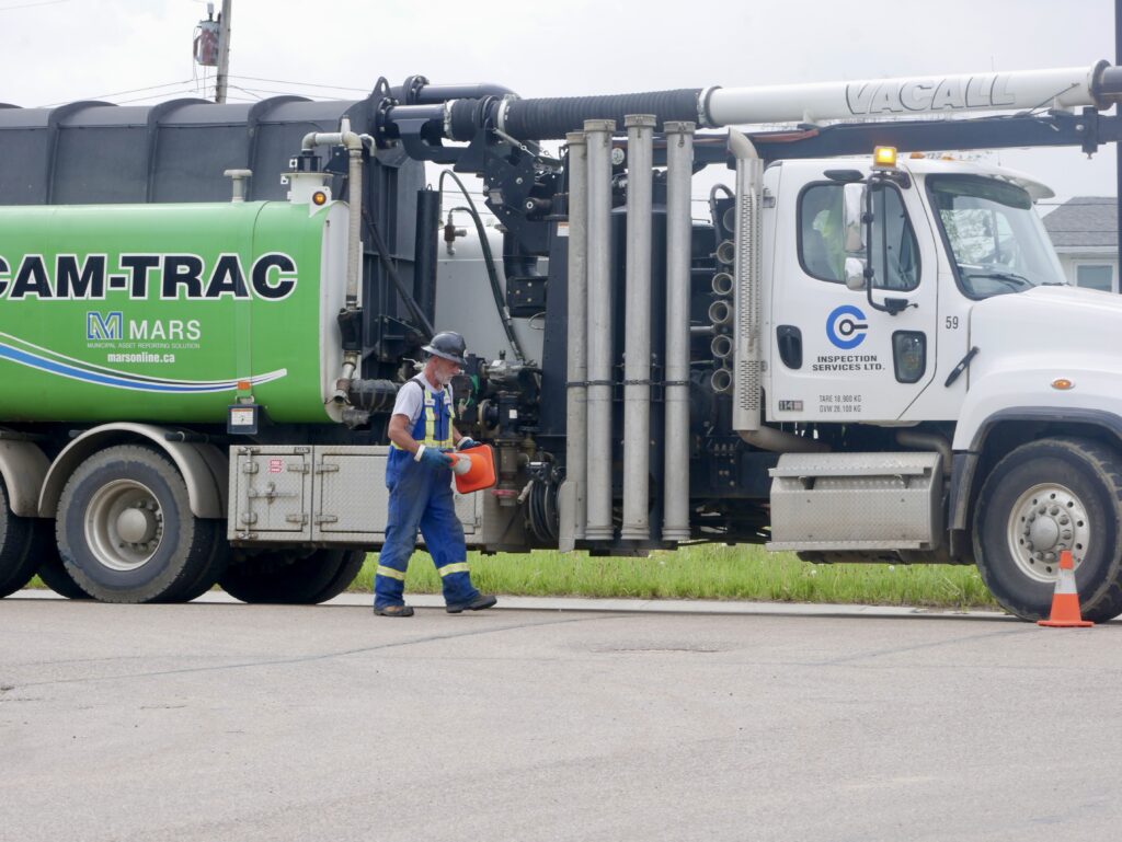 Field worker placing safety pylons on a roadway for traffic control