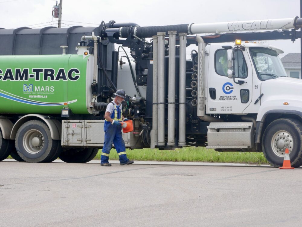Field worker placing safety pylons on a roadway for traffic control