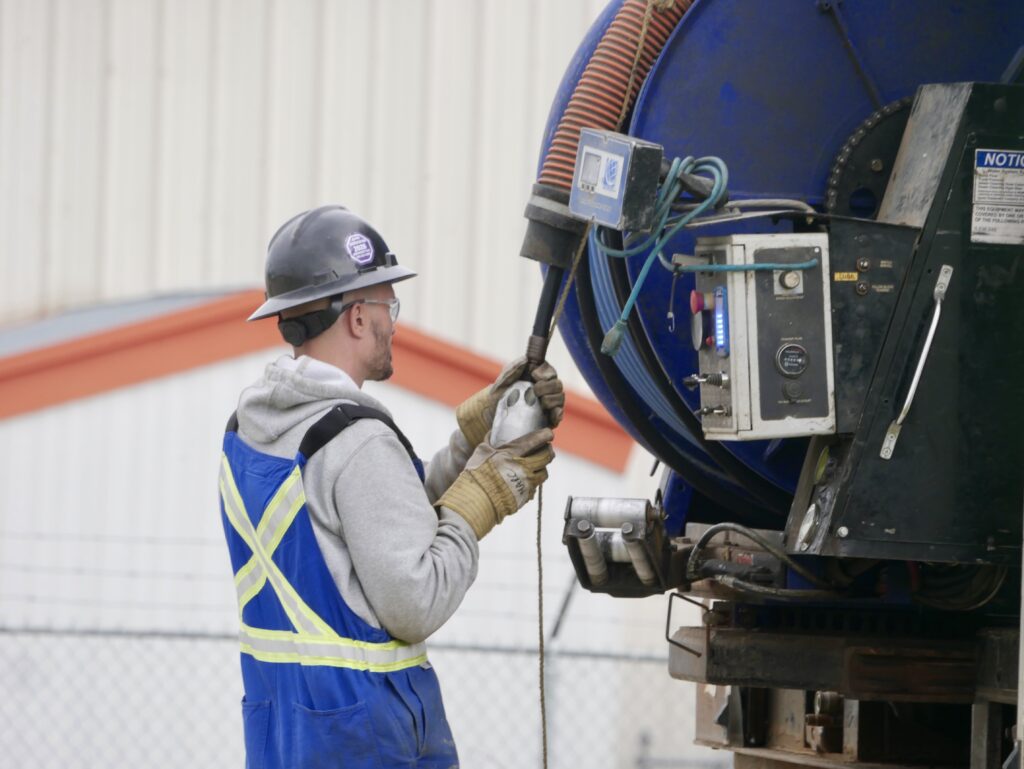 Crew member operating heavy equipment using handheld control device