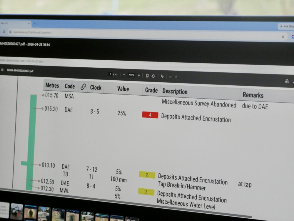 Office staff reviewing inspection data on a computer using NASCCO rating system