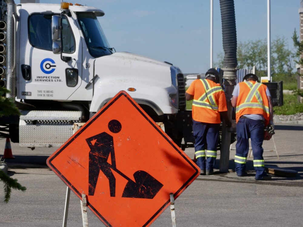 Two Cam-Trac technicians working together on a municipal infrastructure job site.